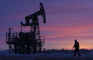A worker walks past a pump jack on an oil field owned by Bashneft company near the village of Nikolo-Berezovka, northwest from Ufa, Bashkortostan, Russia, in this January 28, 2015 file photo. REUTERS/Sergei Karpukhin/Files